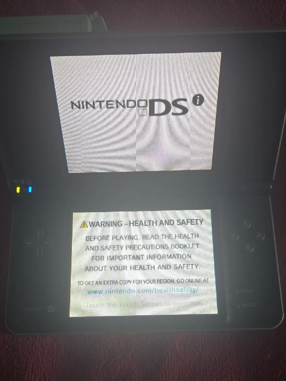 Nintendo DSi XL in black with minor scrapes and scratches